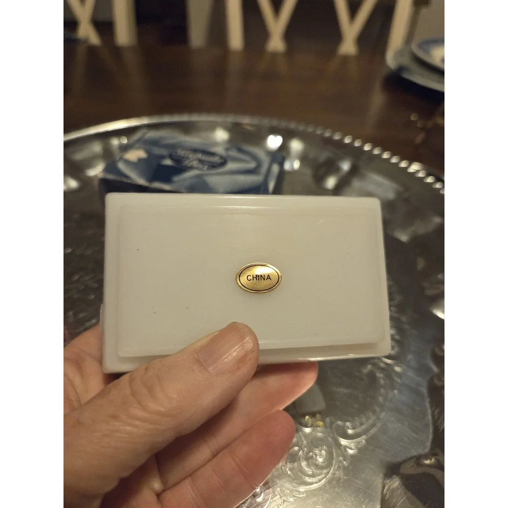 vintage white hinged trinket box features a polished finish with a delicate,...